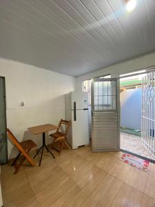 a kitchen with a table and a refrigerator in a room at Pé na Villa in Itacaré