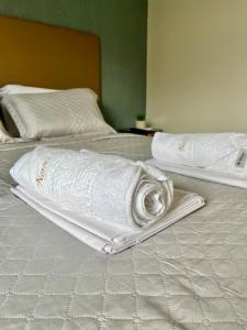 two beds with towels sitting on top of them at Apto Master a 30m da Praça da Sé - Norões Residence in Crato