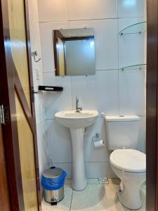 a bathroom with a sink and a toilet and a mirror at Apto Master a 30m da Praça da Sé - Norões Residence in Crato