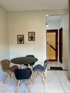 a table and chairs in a room with a door at Apto Master a 30m da Praça da Sé - Norões Residence in Crato