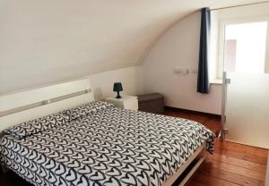 a bedroom with a bed with a black and white comforter at Casa Vacanza Martino in Matera