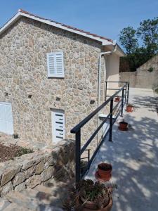 a stone house with a staircase next to a building at Apartman Lasko 1 in Goveđari +5 photos
