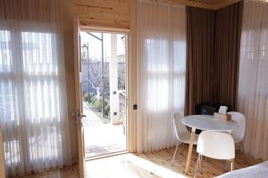 a bedroom with a table and white chairs and a window at Armenian Corner Hotel in Pʼarakʼar