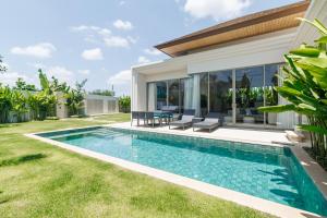 a swimming pool in the backyard of a house at Trichada Essence in Ban Pak Lak