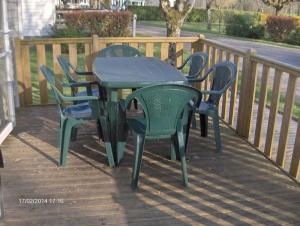 a table and chairs sitting on a deck at Camping 3 étoiles - ccbfgdc in Neuvic