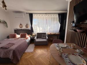 a bedroom with a bed and a couch and a table at Bérc Apartman in Egerszalók