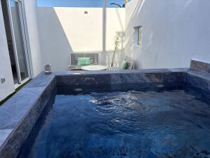 a pool of water in a bathroom with a sink at La Casita de Kai in El Médano