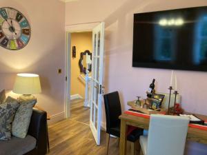a living room with a table and a television on the wall at Mountroyal Victorian Self Catering Apartment 2 in Belfast