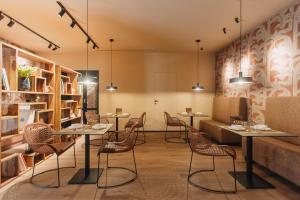 a restaurant with tables and chairs in a room at CŌRA Ortigia in Syracuse