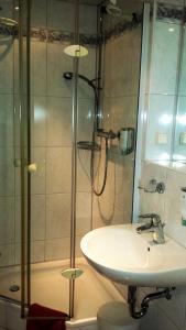 uma casa de banho com um chuveiro e um lavatório. em Siegerland-Hotel em Freudenberg