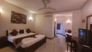 a bedroom with a bed and a flat screen tv at Vintara Wild Hambanthota in Hambantota