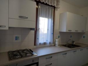 a kitchen with a stove and a sink and a window at Casa Vallati in Scardovari