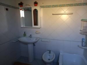 a white bathroom with a sink and a toilet at Casa Vallati in Scardovari