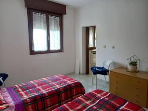 a bedroom with two beds and a dresser and a window at Casa Vallati in Scardovari