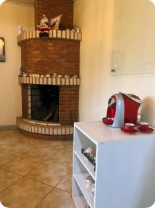 a living room with a brick fireplace and a red appliance at Casa completa com lareira, piscina compartilhada in Torres