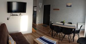 a living room with a table and chairs and a television at Noclegi u Nikoli in Wola Wereszczyńska +4 photos