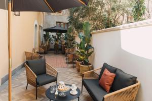 a patio with chairs and tables and an umbrella at CŌRA Ortigia in Syracuse