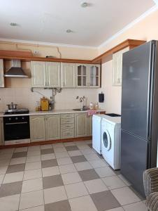 a kitchen with a refrigerator and a washing machine at Фазенда in Bohuslav