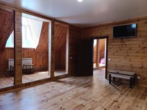 a living room with wooden walls and a flat screen tv at Фазенда in Bohuslav