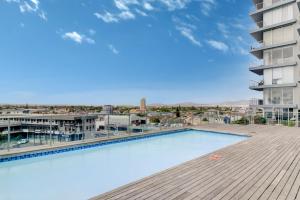 a swimming pool on the roof of a building at Cape Town, Blouberg Beachfront Luxury Apt - Kite Beach in Bloubergstrand