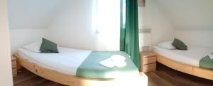 two twin beds in a room with green curtains at Noclegi u Nikoli in Wola Wereszczyńska