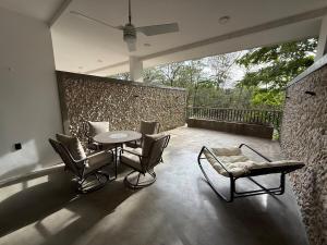 a patio with a table and chairs and a stone wall at Isabel 202! Top studios in Nosara in Nosara
