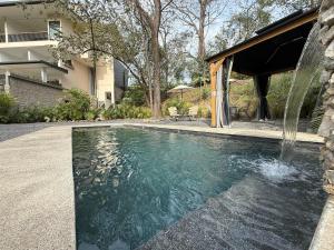 a swimming pool with a water fountain in a yard at Isabel 202! Top studios in Nosara in Nosara +11 photos