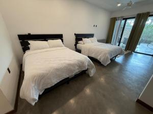 a bedroom with two beds and a large window at Isabel 202! Top studios in Nosara in Nosara