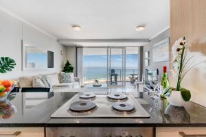 a kitchen and living room with a view of the ocean at Cape Town, Blouberg Beachfront Luxury Apt - Kite Beach in Bloubergstrand