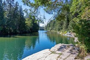 a view of a river with a bridge in the background at Nesting Ravens cottage in Nanaimo