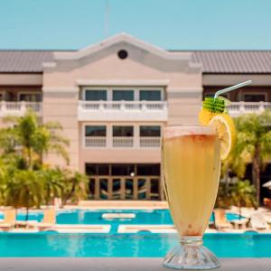 a drink sitting on a table next to a pool at Howard Johnson Hotel & Casino in Formosa
