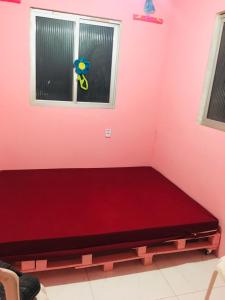 a bed in a room with a pink wall at Casa da BARBIE Praia in Itapipoca