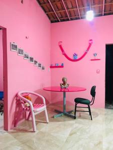 a pink room with a pink table and two chairs at Casa da BARBIE Praia in Itapipoca +4 photos