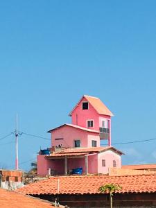 a pink house sitting on top of a roof at Casa da BARBIE Praia in Itapipoca