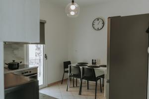 a kitchen with a table and chairs and a clock at Teal Seafront Home in Syvota