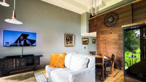 a living room with a couch and a clock on the wall at Lossipark Guest Apartments - vis-à-vis Bishop's Castle in Haapsalu