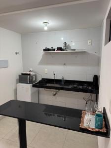 a kitchen with a black counter top in a room at Flat aconchegante com vista pro açude in Campina Grande +6 photos