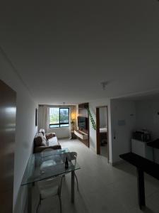 a living room with a couch and a glass table at Flat aconchegante com vista pro açude in Campina Grande