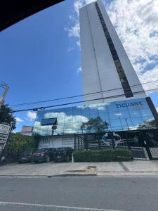 a building with cars parked in front of it at Flat aconchegante com vista pro açude in Campina Grande