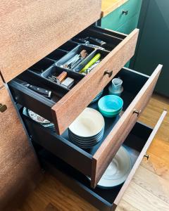 a drawer in a kitchen with plates and utensils at Lossipark Guest Apartments - vis-à-vis Bishop's Castle in Haapsalu +25 photos