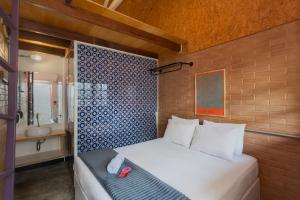 a bedroom with a bed and a bathroom with a sink at Ô de Casa Hostel Bar in São Paulo