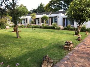a house with a yard with grass and trees at 6 on Morris Guest Lodge in Johannesburg