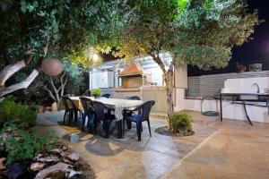 a patio with a table and chairs in a garden at Skamagkas G. Apartments in Stavros