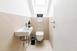 a bathroom with a sink and a toilet and a window at Das Salzamt - Boutique Apartments in Gmunden