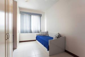 Un dormitorio con una cama azul y una ventana en Apto Cabo Frio Marina Clube, en Cabo Frío
