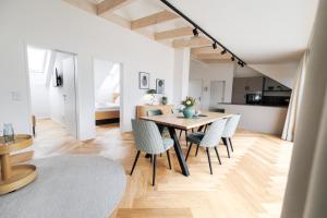 a dining room and kitchen with a table and chairs at Das Salzamt - Boutique Apartments in Gmunden