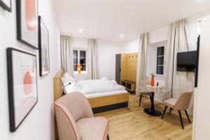 a bedroom with a bed and a table and chairs at Das Salzamt - Boutique Apartments in Gmunden
