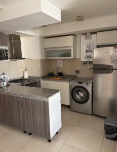 a kitchen with a washing machine and a washer at Brisa del mar in Comodoro Rivadavia