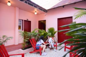 two women sitting on red chairs outside of a house at Casa Remolacha in Flores