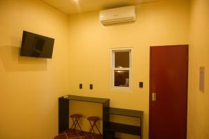 a room with two stools and a tv and a mirror at Casa Remolacha in Flores